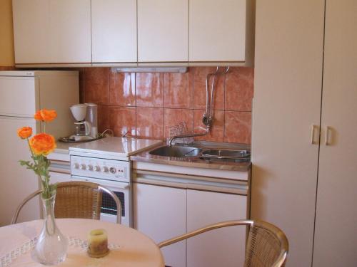 泰斯Apartments by the sea Stanici, Omis - 4585的厨房配有水槽和花瓶桌子