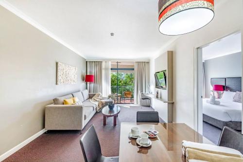 达尔文'Double Paradise' Twin Waterfront Resort Apartments的带沙发的客厅和带沙发床的房间