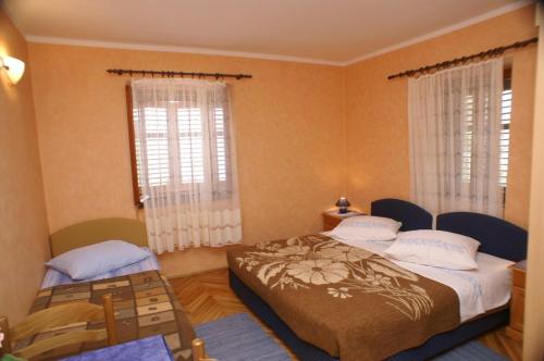 特雷斯塔尼克Apartments by the sea Trstenik, Peljesac - 4511的一间卧室设有两张床和两个窗户。