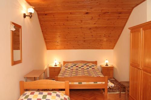 拉茨斯切Apartments by the sea Racisce, Korcula - 4362的一间卧室设有两张床和木制天花板