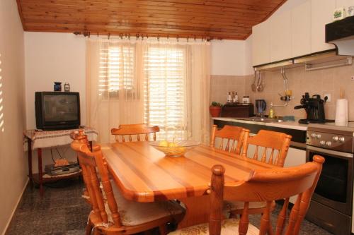 拉茨斯切Apartments by the sea Racisce, Korcula - 4362的厨房配有木桌、椅子和电视