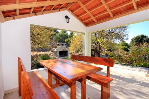 尼亚卢卡Seaside holiday house Cove Gradina, Korcula - 4457的门廊上设有一张木桌和两把椅子,享有庭院的景色