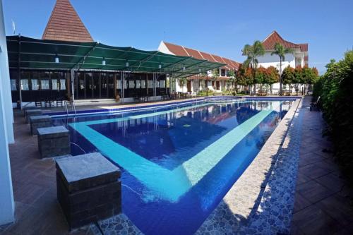 梭罗Al Azhar Azhima Hotel Resort and Convention的大楼内一个蓝色的大型游泳池