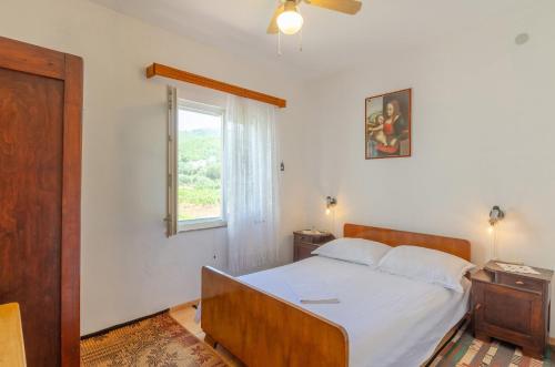 普利兹巴Apartments by the sea Prizba, Korcula - 4479的一间卧室配有一张带白色床单的床和一扇窗户。