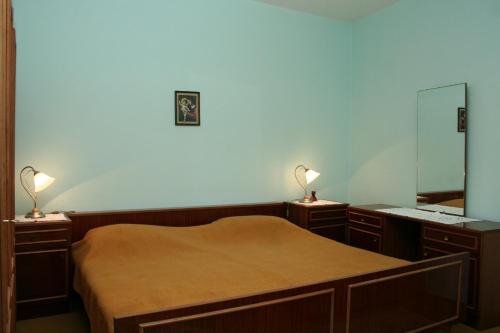 韦伯斯卡Rooms by the sea Vrboska (Hvar) - 4600的一间卧室配有一张带两盏灯和镜子的床