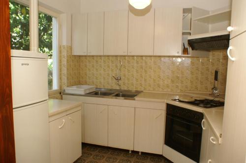 库希斯特Apartments by the sea Kuciste - Perna, Peljesac - 4540的厨房配有白色橱柜和炉灶烤箱。