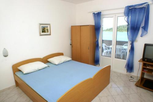 赞吉纳Apartments by the sea Luka Dubrava, Peljesac - 4568的一间卧室配有一张床、一台电视和一个阳台