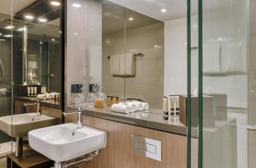 布里斯班The Point Brisbane Hotel的一间带水槽和镜子的浴室