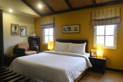 蓬蒂切里里士满酒店的一间卧室配有一张床、一把椅子和窗户。