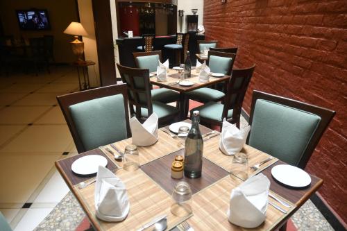 蓬蒂切里里士满酒店的餐厅配有桌椅和一瓶葡萄酒