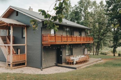 马多纳Sniegi Apartments with sauna的房屋设有甲板和桌子