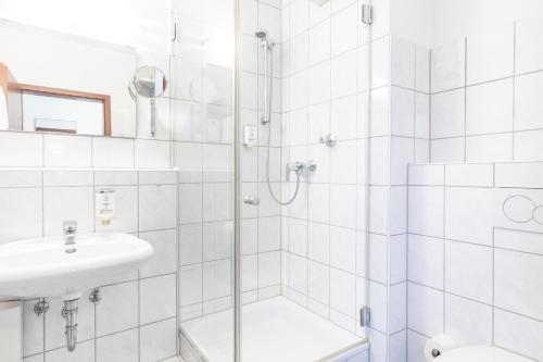 杜塞尔多夫acora Düsseldorf Living the City的带淋浴和盥洗盆的白色浴室