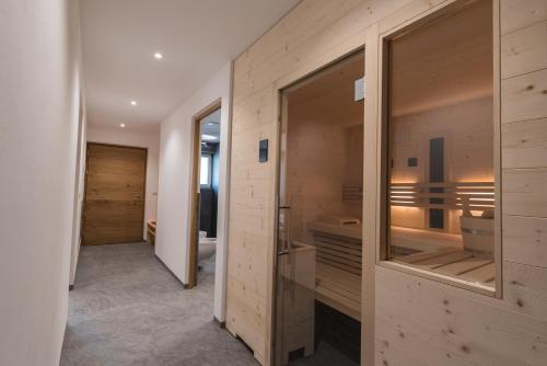 布列瑟农Mesnerhof Chalet的一间带木墙和步入式淋浴间的浴室