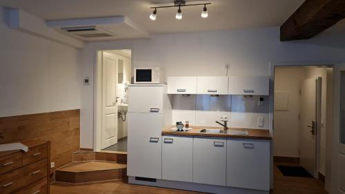 爱尔福特住宿酒店的厨房配有白色橱柜和白色冰箱。