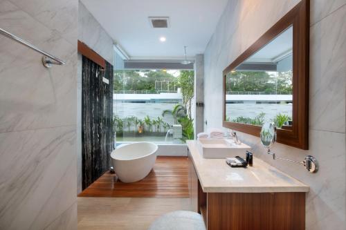 塞米亚克The Daha Luxury Villas的一间带大浴缸和大窗户的浴室