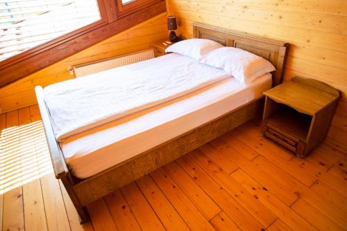 苏恰瓦Sat de vacanta Ciprian Porumbescu的木地板客房的一张床位