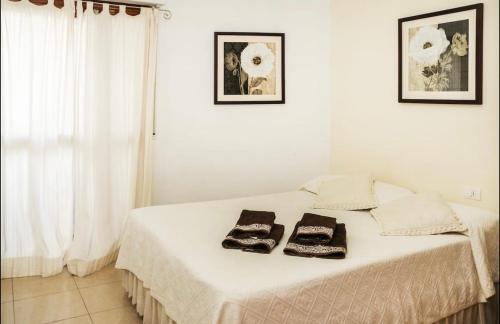 圣克鲁斯-德特内里费阿特兰提大公寓的一张白色的床,上面有两条毛巾