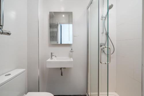 伦敦JOIVY 2-bed flat with garden in Battersea的白色的浴室设有水槽和淋浴。