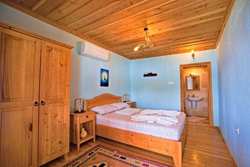 Kaleucagız卡莱民宿的一间卧室设有一张床和木制天花板