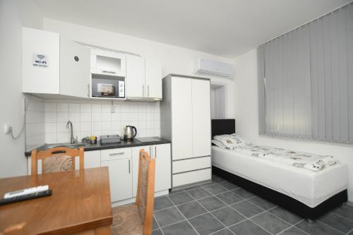 克拉多沃Relax Apartmani Rooms的一间带床和桌子的小厨房