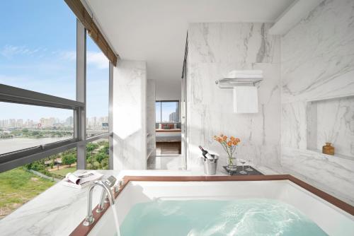 胡志明市Oakwood Hotel & Apartments Saigon的带浴缸的浴室和大窗户