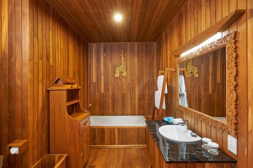 娘瑞KMA Inle Hotel的木制浴室设有水槽和浴缸