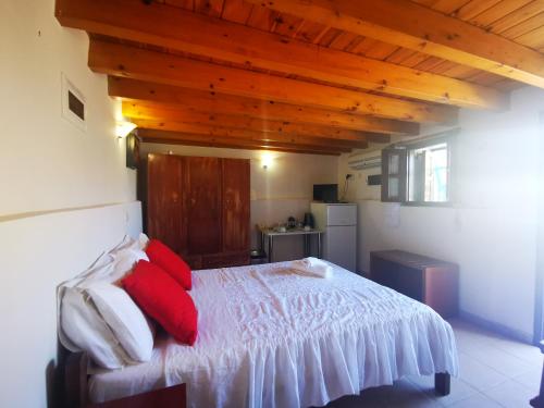 哈尔基岛Kalypso apartment的一间卧室配有红色和白色枕头的床