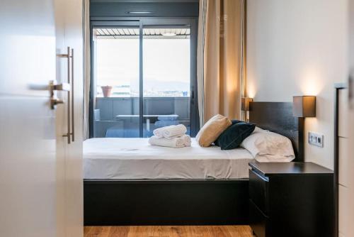 格拉纳达Moderno apartamento con Piscina y Parking的一间卧室配有带毛巾的床