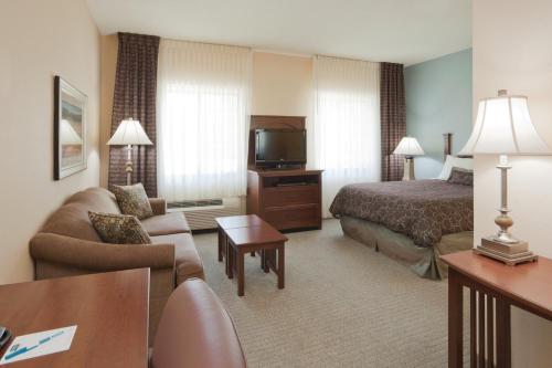 拉斐特拉斐特机场驻桥套房酒店的酒店客房设有床、沙发和电视。