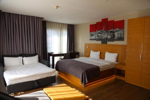 伊斯坦布尔塔克辛超多套房酒店的酒店客房配有两张床和一张书桌
