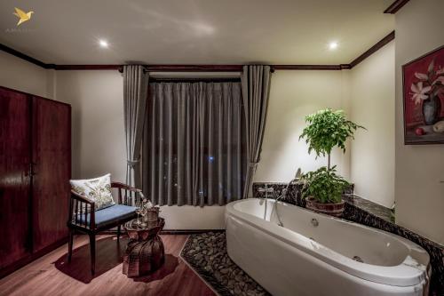 胡志明市Amanaki Saigon Boutique Hotel的一间带大浴缸和椅子的浴室