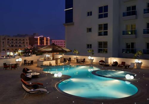迪拜迪拜艾尔里加凯悦酒店的夜间酒店中央的游泳池