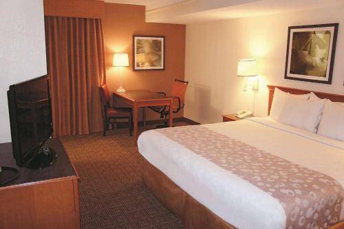 奥古斯塔Days Inn by Wyndham Augusta Washington Rd的配有一张床和一张书桌的酒店客房