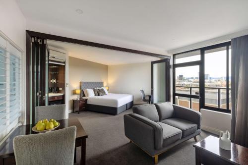 阿德莱德Rydges South Park Adelaide的酒店客房配有床、沙发和桌子。