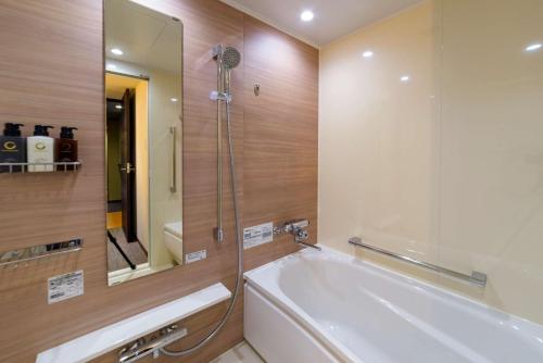 千岁千岁菲诺贝斯特韦斯特优质酒店的带浴缸和镜子的浴室