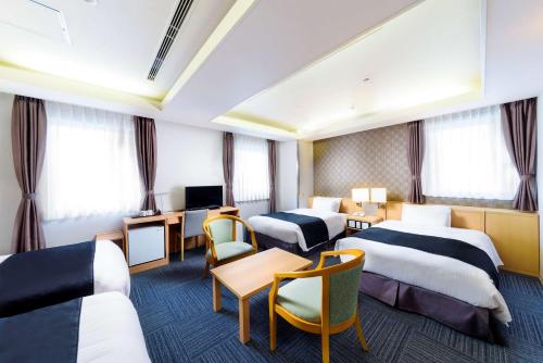 大阪SureStay Plus Hotel by Best Western Shin-Osaka的酒店客房设有三张床和电视。
