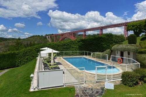 罗巴热瑟Logis Hôtel Beau Site的一座带桥的游泳池