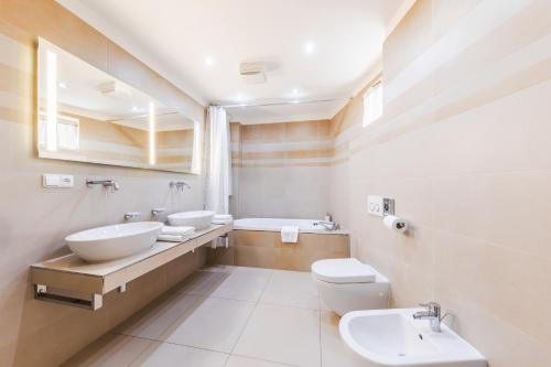 布拉格Aparthotel Tycho de Brahe的浴室设有2个水槽和2个卫生间