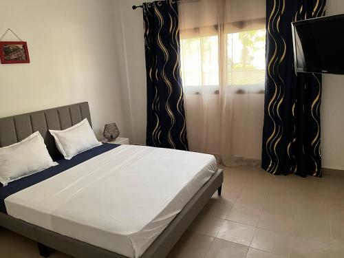 达喀尔Residence B&B Hibiscus的一间卧室设有一张大床和一个窗户。