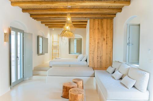 考弗尼西亚Mystic Villas Koufonisi的客厅配有白色家具和木制天花板。