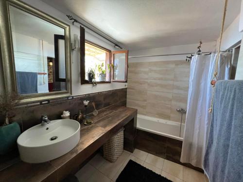 RodhiáΠετροχτιστο Αρχοντικό με υπεροχή θεα的浴室配有盥洗盆、镜子和浴缸