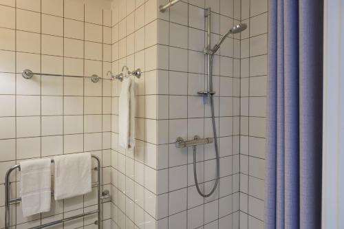 欧登塞第一豪华酒店的一间带蓝色淋浴帘的淋浴的浴室
