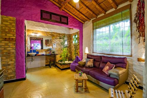 亚美尼亚Hotel Campestre Solar De La Luna的一间带紫色沙发的客厅和一间厨房