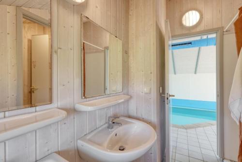 HohendorfKranich Ferienhäuser mit Innenpool的一间带水槽和两面镜子的浴室