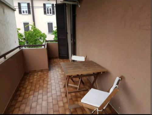 贝加莫贝尔加莫和丁多尼酒店的阳台配有木桌和2把白色椅子