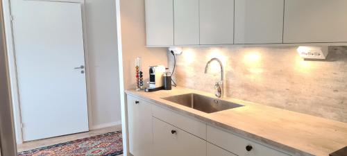 克里斯蒂安斯塔德LUXURY CITY VIEW APARTMENT的厨房配有水槽和白色橱柜