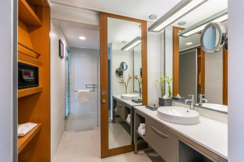 艾哈迈达巴德Vivanta Ahmedabad SG Highway的一间带两个盥洗盆和大镜子的浴室
