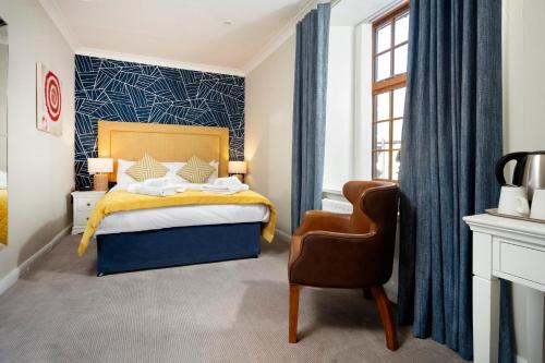 巴姆博格维多利亚酒店的一间卧室配有一张床和一把椅子