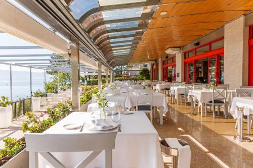 桑亨霍圣森索塔拉索大酒店的一间设有白色桌椅的海洋餐厅