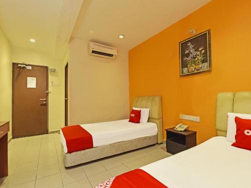 新山OYO 90510 Hotel Sahara的酒店客房,设有两张带橙色墙壁的床